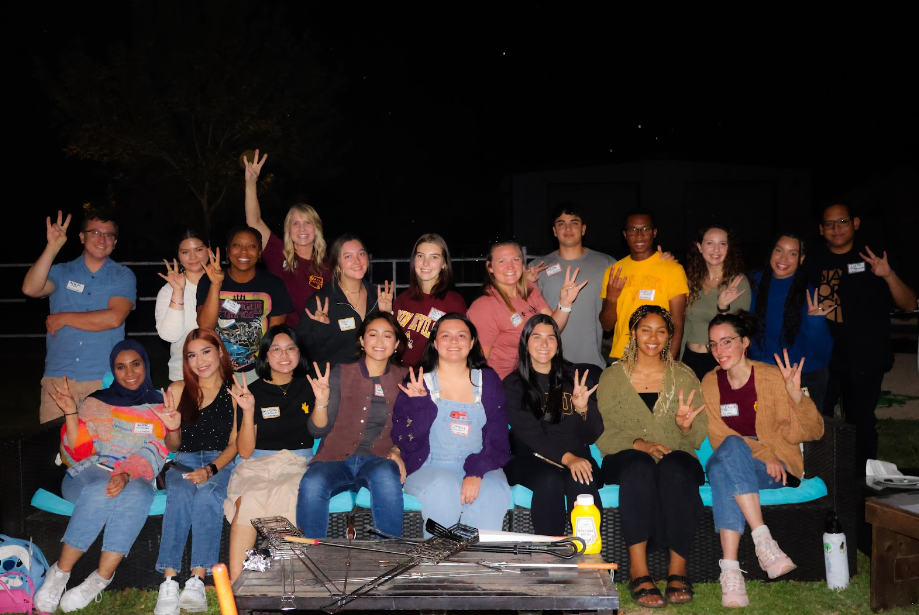 Students sit around the campfire at the fall fireside event