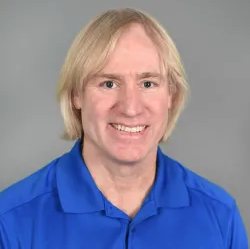 Gordon Shockley headshot - fair-skinned man, smiling, blond hair, blue collared shirt