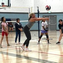 Girls and their coach playing volleyball during the first eight-week clinic launched in fall 2023.