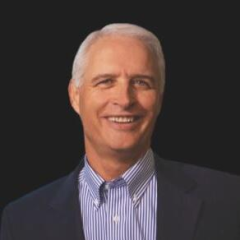 Robert Ashcraft headshot - fair-skinned man, smiling, white hair, blue-and-white-striped collared shirt, navy blazer