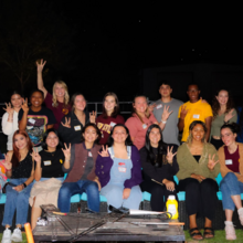 Students sit around the campfire at the fall fireside event